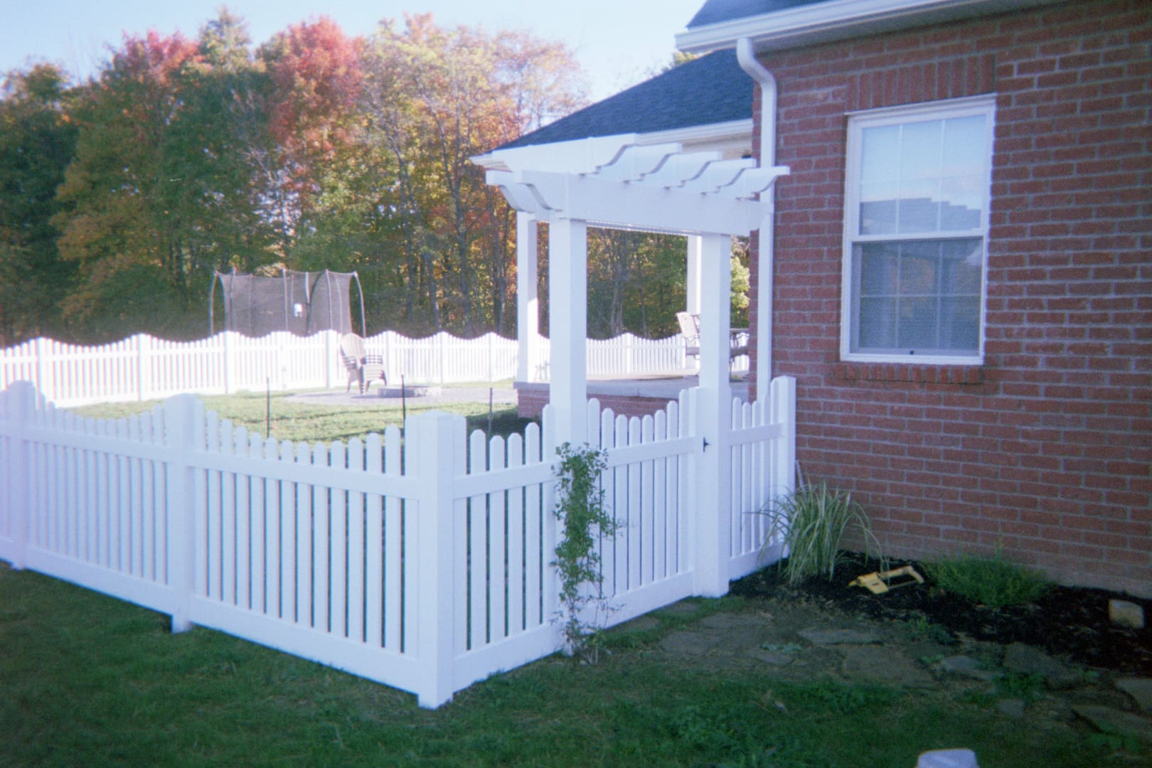 White picket fence beside brick house