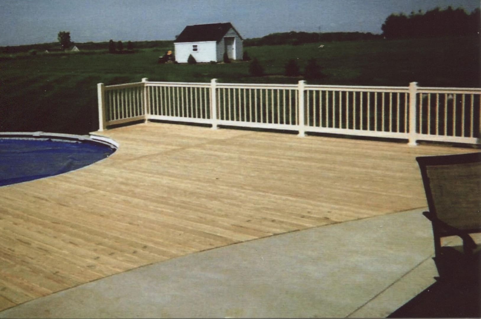 Backyard deck with white railing and shed